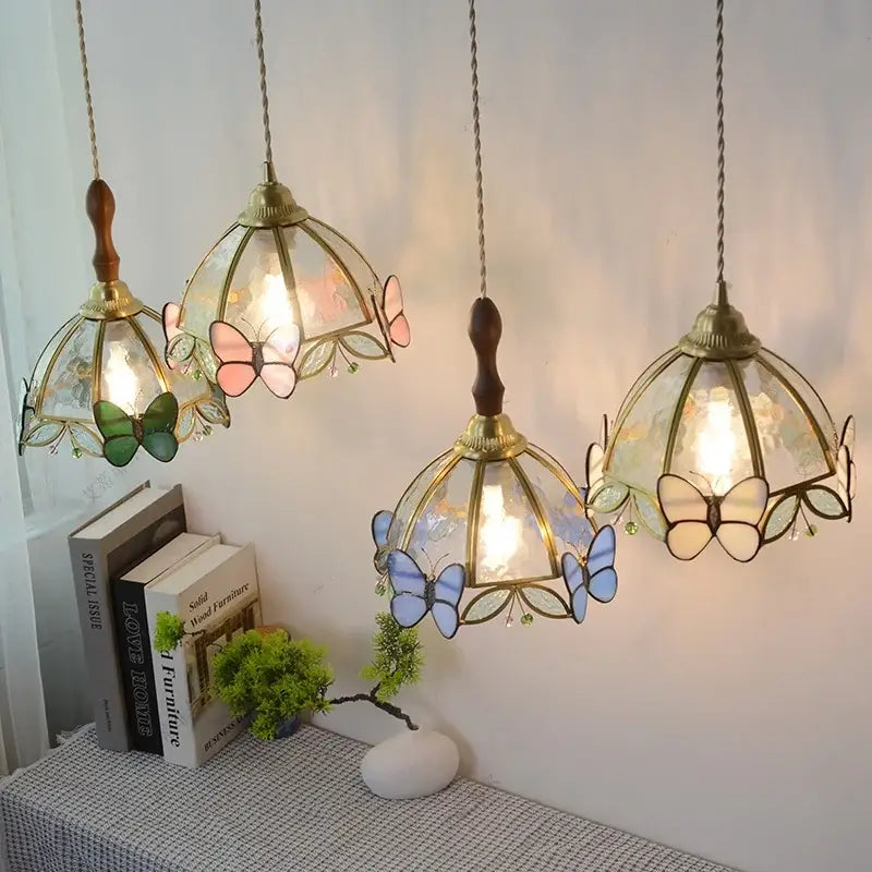 Four modern blue and gold butterfly glass led pendant light fixtures with brass frames and stained glass shades by decorbites pendant light