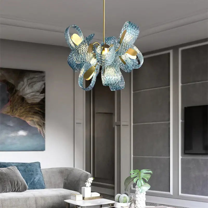 A modern blue decorbites glass chandelier with woven petal design and gold-toned accents for dining room lighting