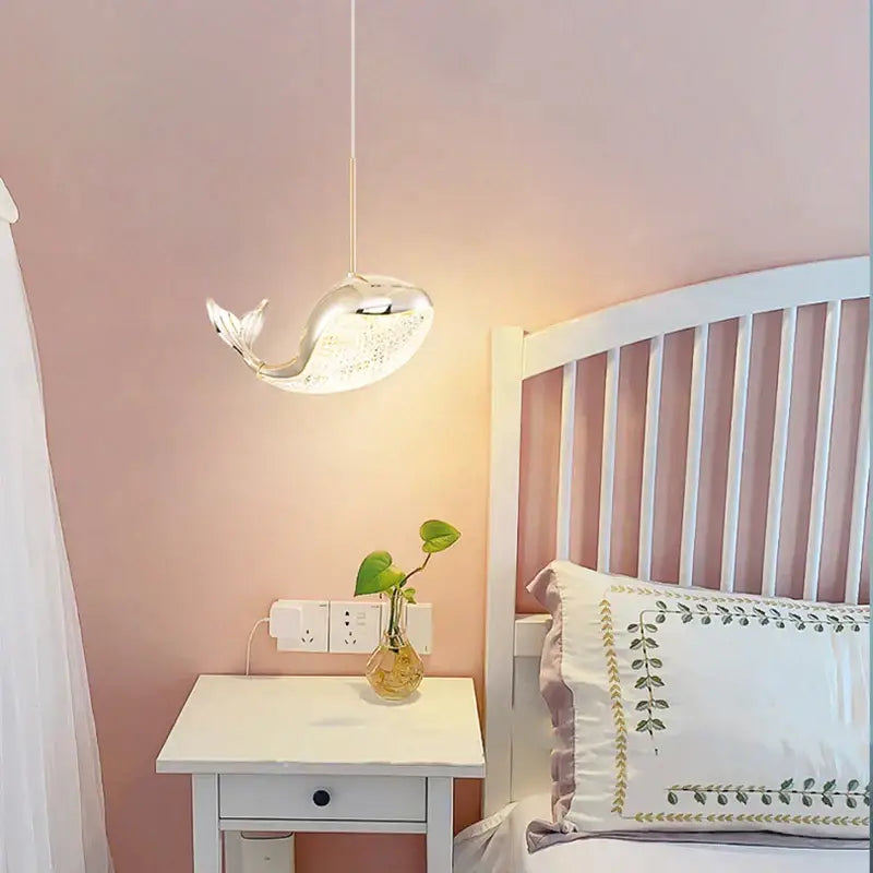 A sleek transparent glass decorbites dolphin chandelier with silver finish and internal led lighting for bedroom decor