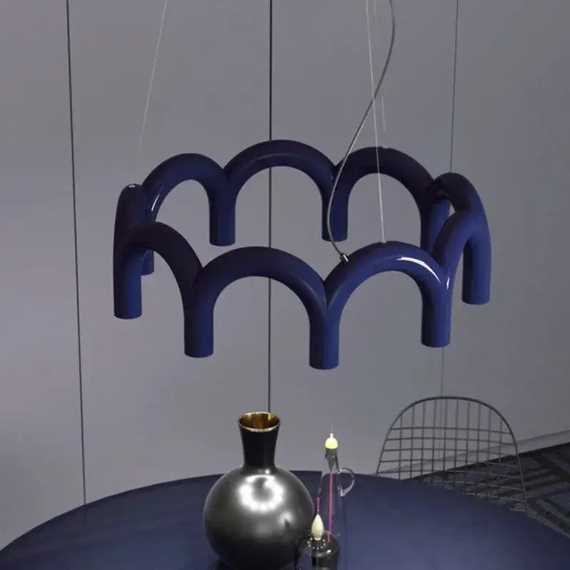 Modern blue metal arch chandelier featuring a deep blue glossy ceramic pendant light with a wave-like design