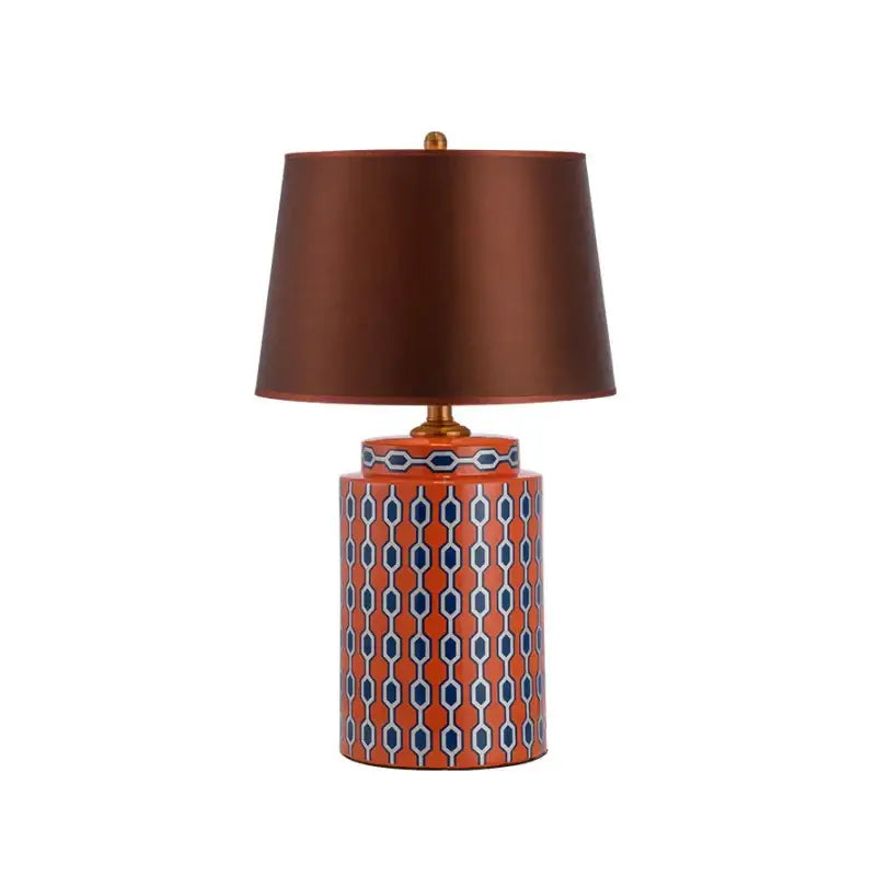 Modern blue orange ceramic table lamp with a vibrant geometric pattern and a brown satin shade for bedroom decorbites