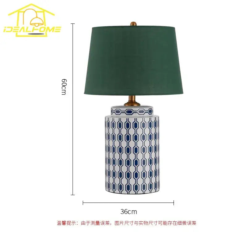 Modern blue orange ceramic table lamp with white body, blue geometric patterns, dark green shade, and gold fittings for decorbites