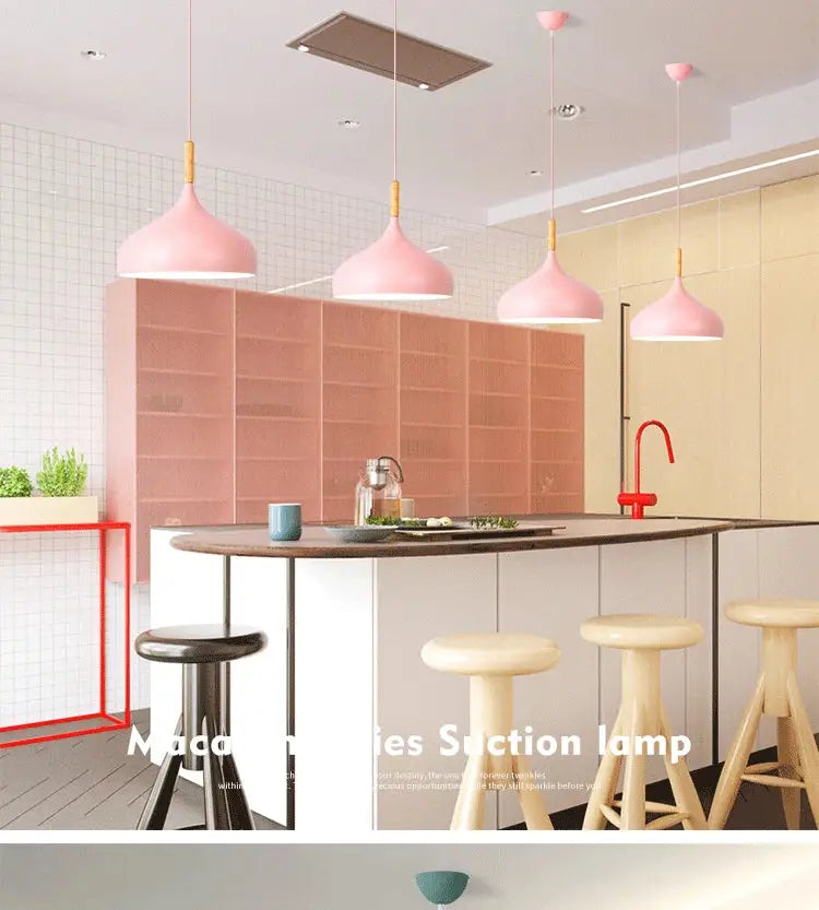Pink conical pendant light with gold fixtures and wood accent helps create a modern kitchen ambiance