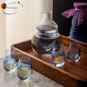 Modern clear glass wine pot ice jug set with bulbous carafe and four blue tinted base glasses for dining room use