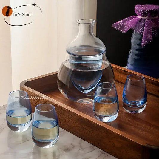 Modern clear glass wine pot ice jug set with bulbous carafe and four blue tinted base glasses for dining room use