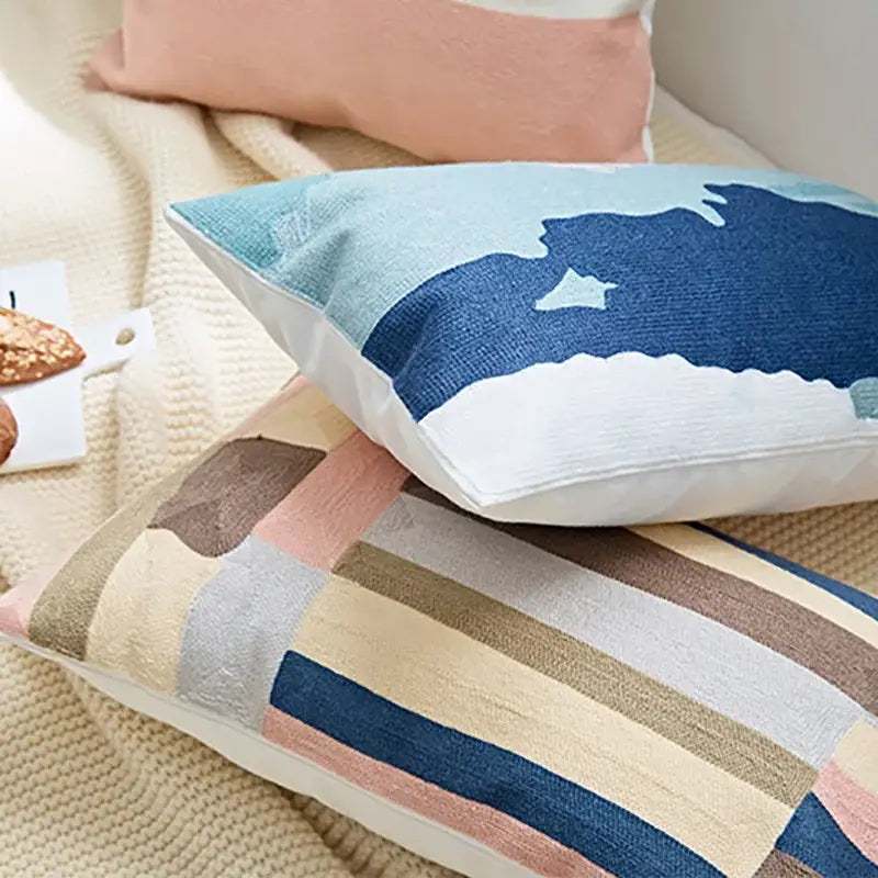 Rectangular embroidered geometric cotton cushion cover with modern abstract stripes in soft blues and earth tones for bedroom