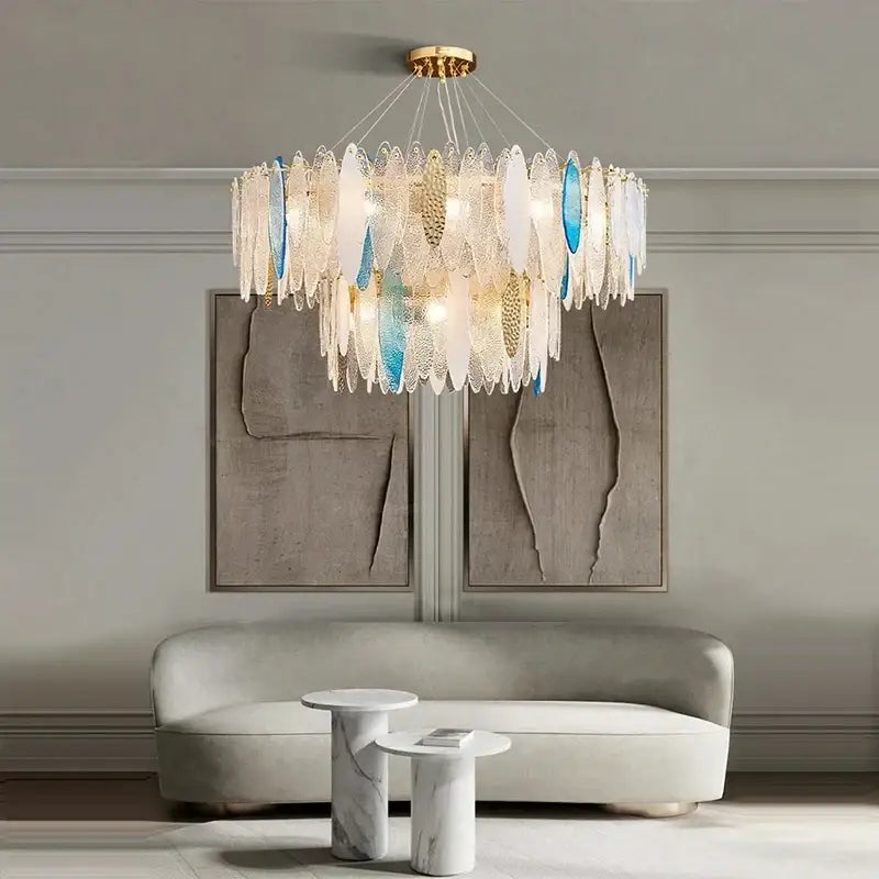 A modern pendant light featuring blue and white glass leaf shades with a gold metal chain by decorbites gold metal