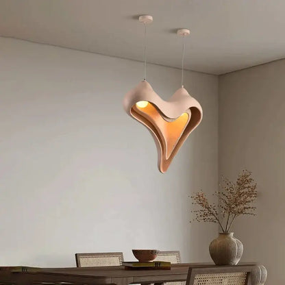 Modern blush pink ceramic pendant light with sculptural design and warm amber glow for dining room decorbites conch chandelier