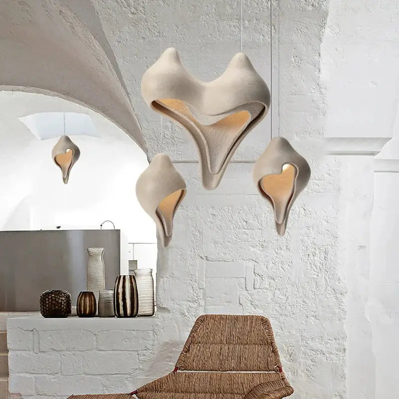 Cream-colored ceramic pendant light with sculptural shell-like forms and warm lighting decorbites conch chandelier