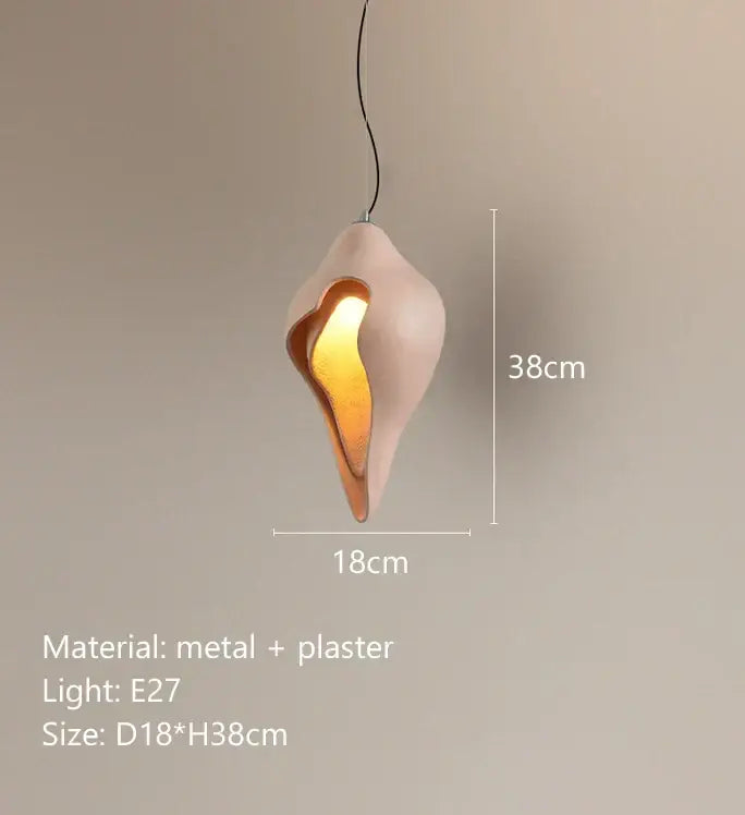 Modern blush pink ceramic pendant light shaped like a seashell with warm amber glow decorbites conch chandelier