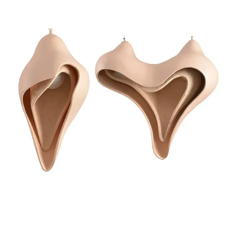 Beige sculptural leather earrings with fluid abstract design complement modern blush pink ceramic pendant light decorbites conch