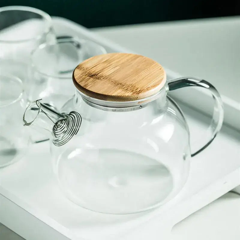 Modern borosilicate glass teapot with transparent borosilicate glass body, bamboo lid, and stainless steel spout for tea