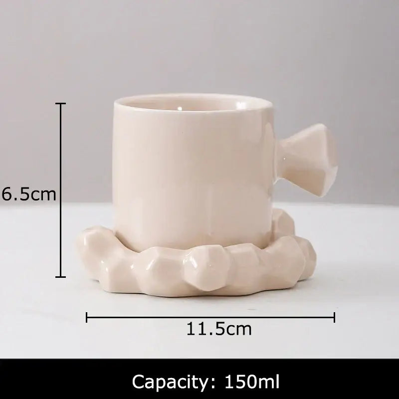 Cream-colored decorbites bowknot decor porcelain cup with faceted geometric handle and matching coaster for dining room use