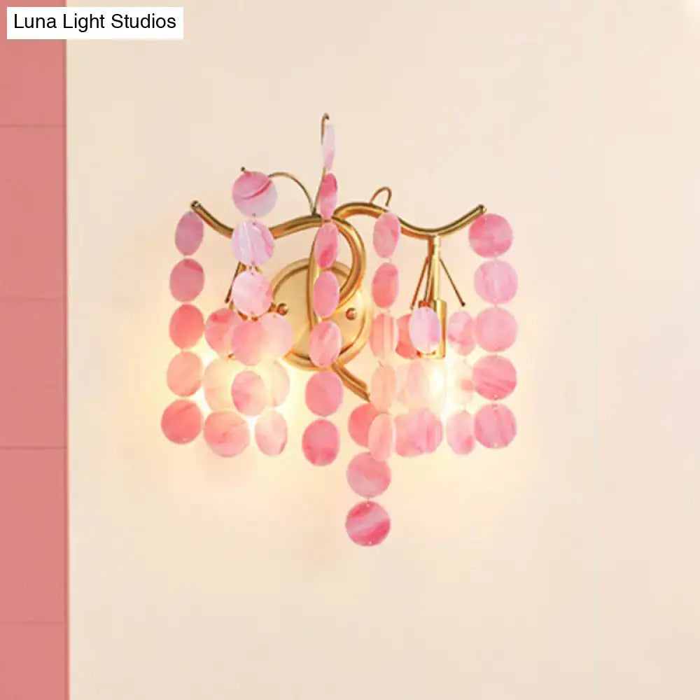 A delicate pink branch design wall lamp with gold metal frame and translucent glass discs for bedroom sconce use