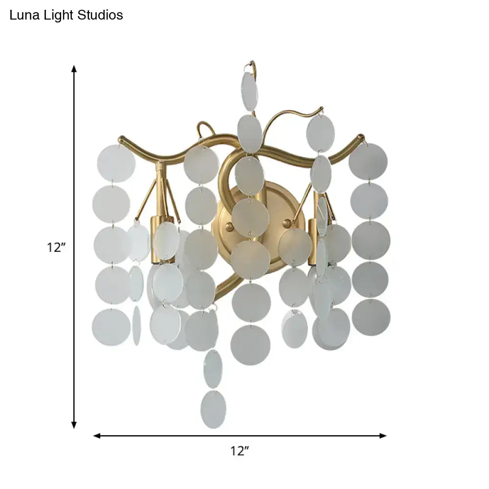 Gold-toned wall lamp with branch design featuring cascading white circular discs ideal for branch design bedroom decor