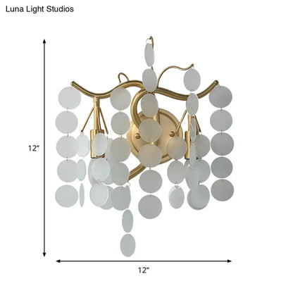 Gold-toned wall lamp with branch design featuring cascading white circular discs ideal for branch design bedroom decor