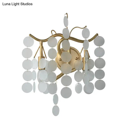 Gold-toned wall lamp with branch design featuring cascading white translucent discs for branch design bedroom use