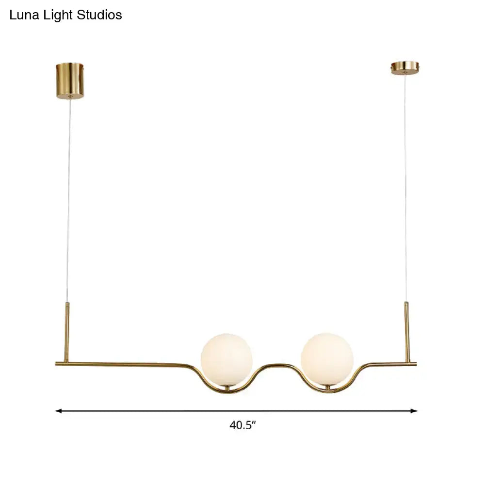 Gold-toned modern pendant ceiling light with two frosted white glass shades and adjustable cords for living room use