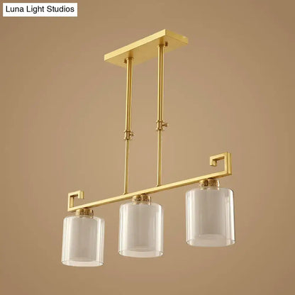 Gold-toned decorbites™ classic cylinder island lighting with three clear glass pendulum lamps and brass finish frame