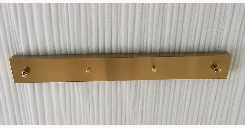 Gold-colored metal coat rack with four hooks paired with modern brass 3 hole decorbites ceiling plate for dining room decor
