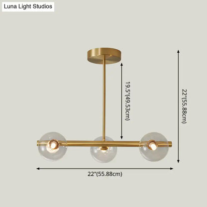 Modern brass pendant light with five spherical glass shades in a brass finish for dining room use