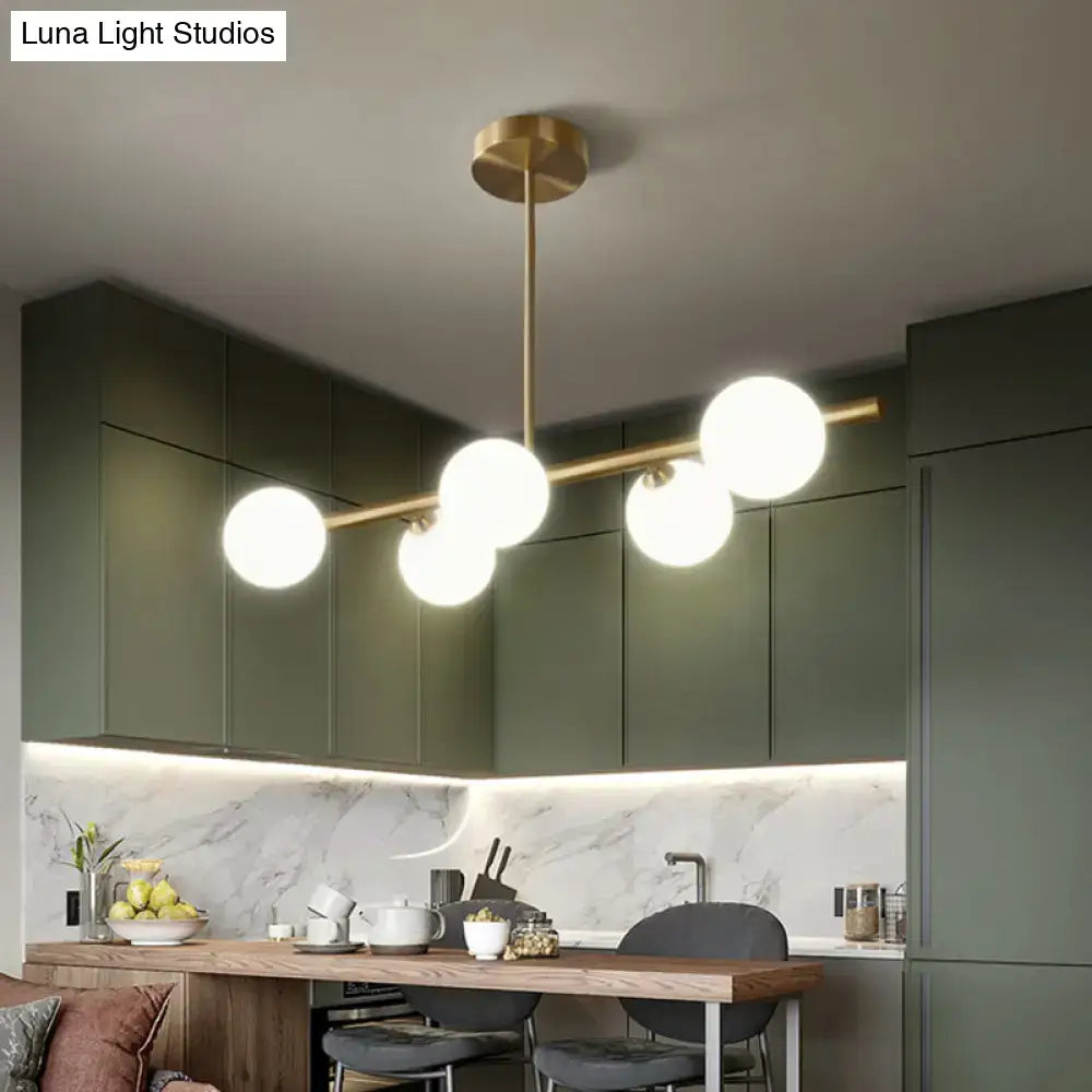Modern brass 5-light pendant light with spherical glass shade featuring five spherical glass globes for dining room use