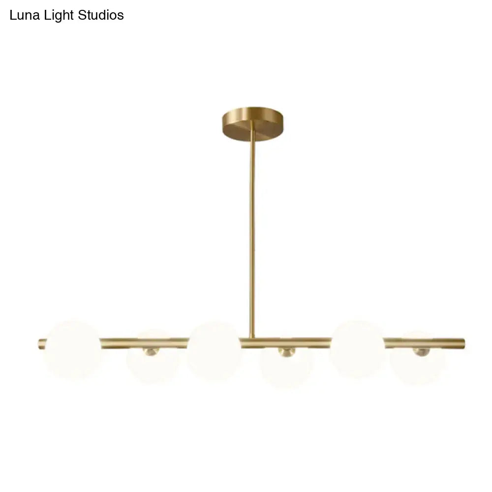 Modern brass 5-light pendant light with spherical glass shades and minimalist horizontal bars for dining room