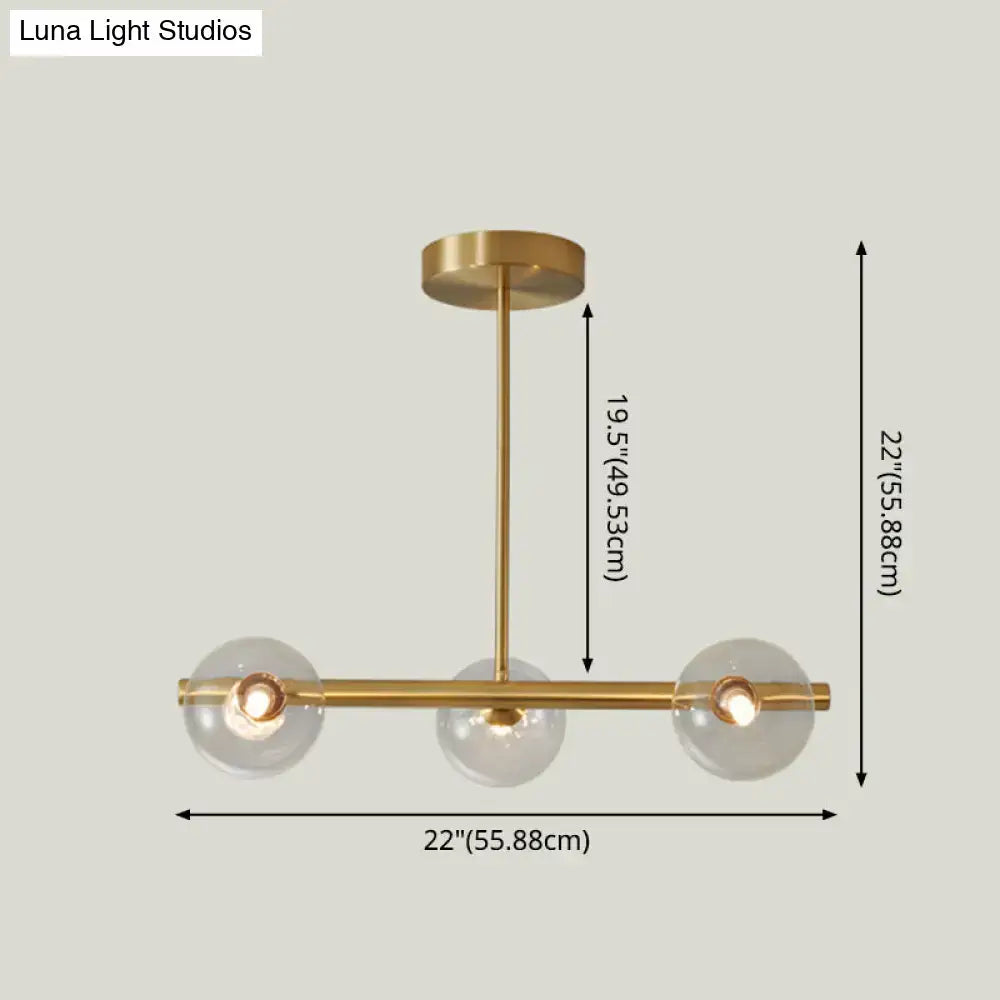 Modern brass 5-light pendant light with spherical glass shade featuring three clear glass globes for dining room use