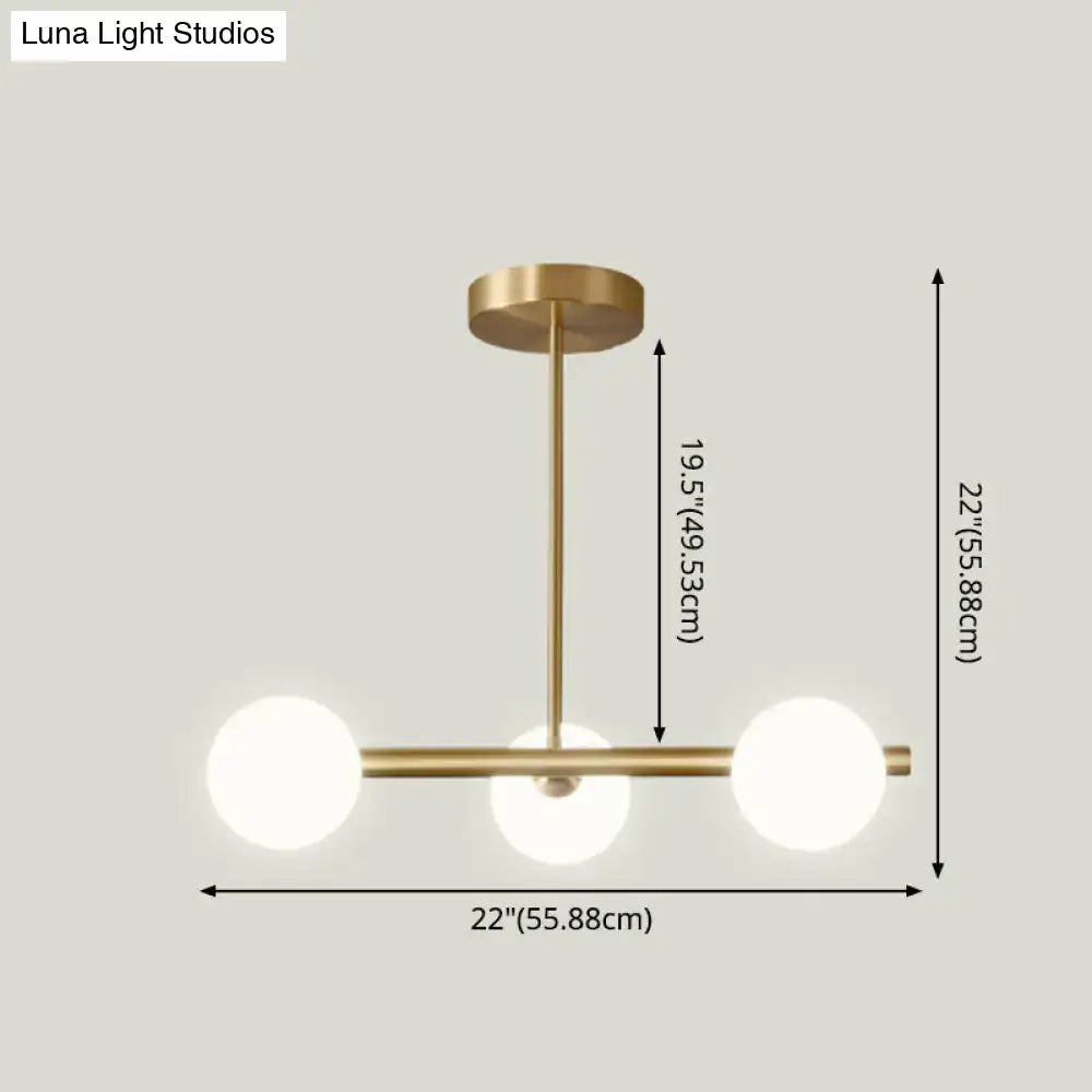 Modern brass pendant light with three spherical glass shade bulbs designed for dining room illumination