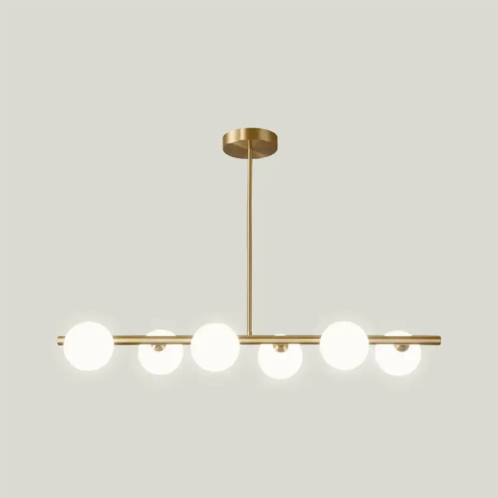 Modern brass 5-light pendant light with gold-toned spherical glass shade globes for dining room lighting