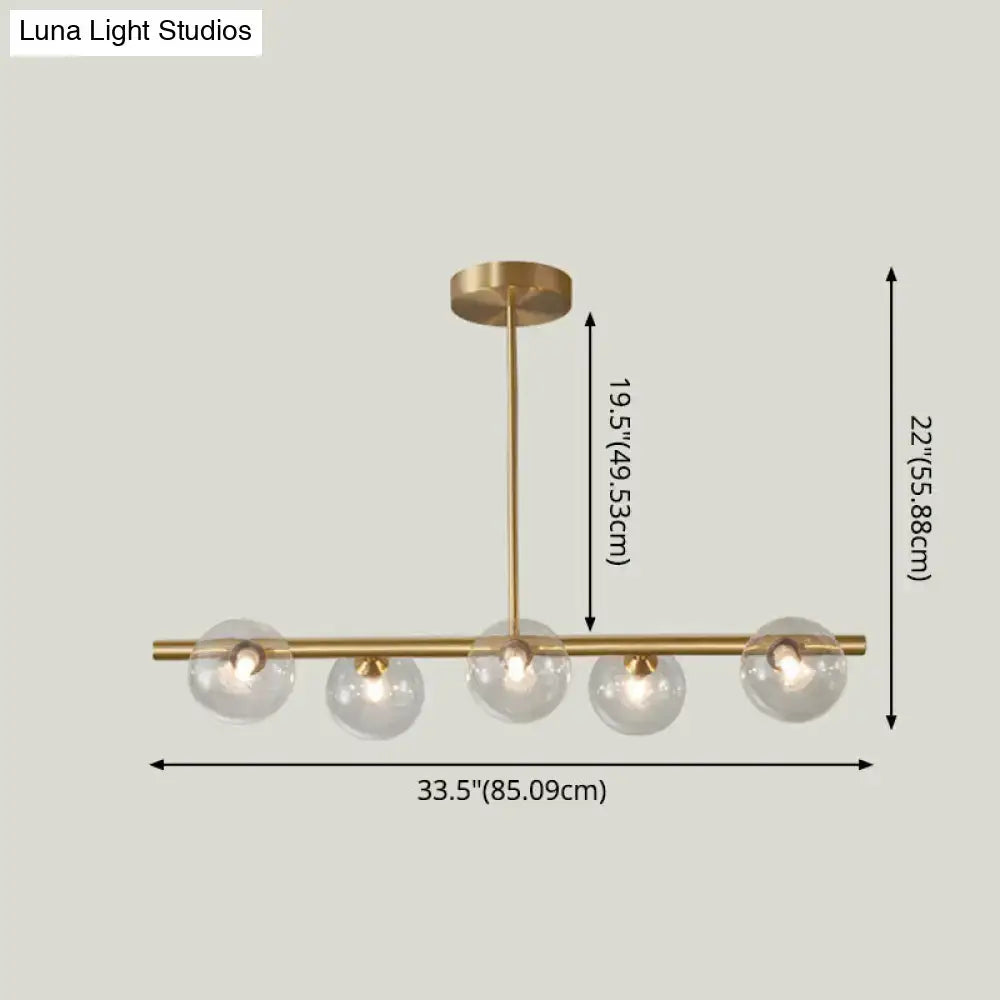 Modern brass pendant light with five spherical glass shade bulbs for dining room lighting
