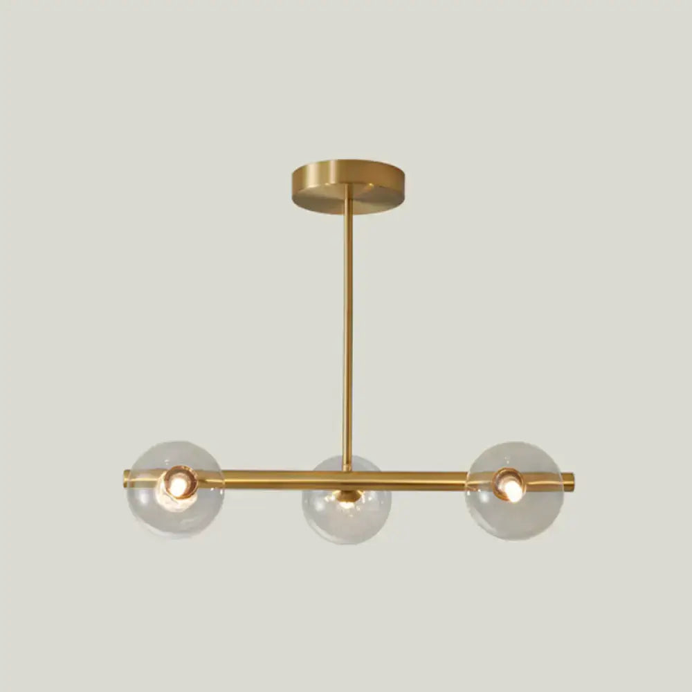 Modern brass pendant light with five spherical glass shades and gold-toned minimalist metal arms for dining room