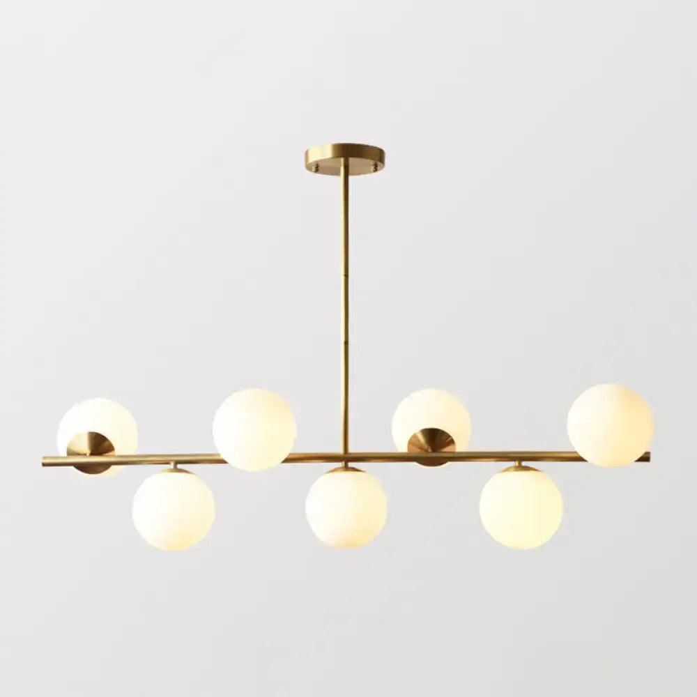 Decorbites sleek cream glass spherical dining room pendant light with six brass globes in modern linear design