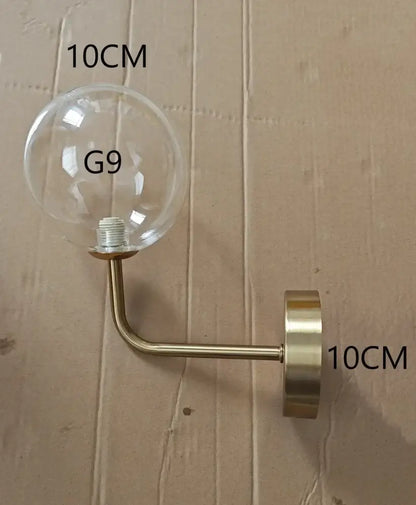 Modern brass amber glass ball wall lamps featuring clear glass globe sconce with brass metal arm for decorbites glass ball wall lighting