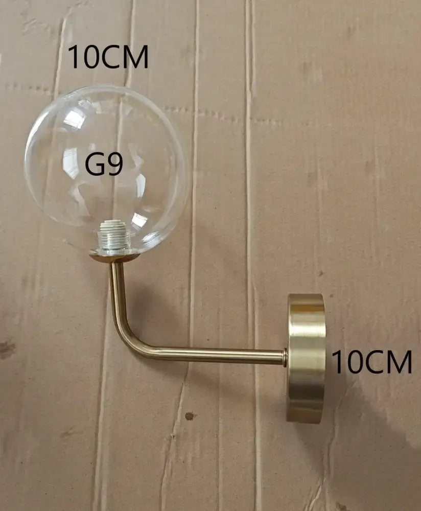 Modern brass amber glass ball wall lamps featuring clear glass globe sconce with brass metal arm for decorbites glass ball wall lighting