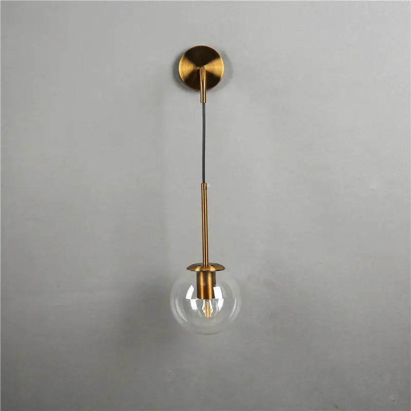 Modern brass amber glass ball wall lamps featuring brass-finished pendant light with clear glass globe for wall lamps decorbites glass ball