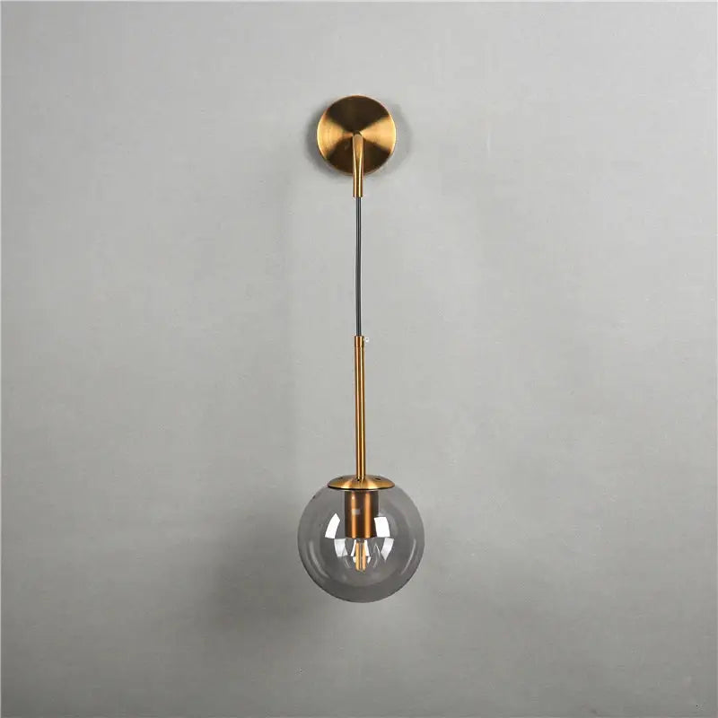 Modern brass amber glass ball wall lamps featuring gold-toned spherical pendant with smoked glass globe decorbites glass ball