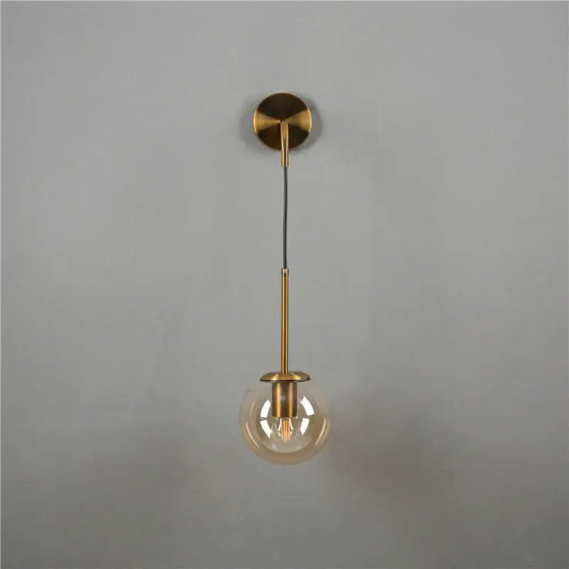 Minimalist modern brass amber glass ball wall lamp with spherical globe and exposed filament bulb for bedroom decorbites glass ball wall lamps