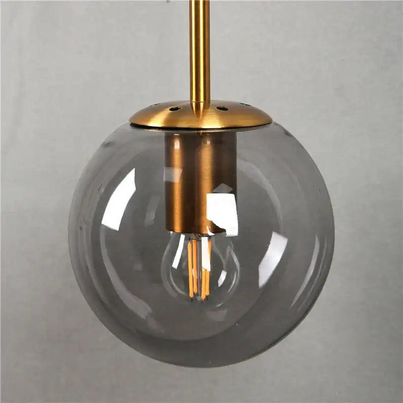Modern brass amber glass ball wall lamp with translucent gray glass globe and exposed led filament bulb for bedroom decorbites wall lamps