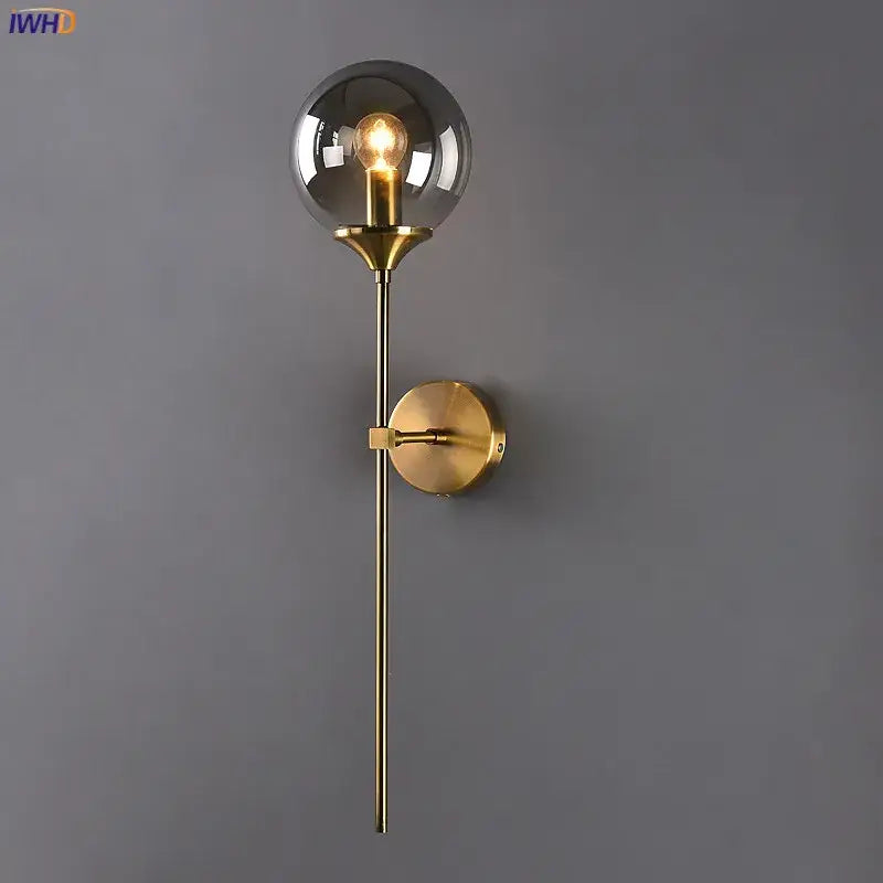 Modern brass and amber decorbites glass ball wall lamp with gold-toned stem and smoked glass globe for bedroom lighting