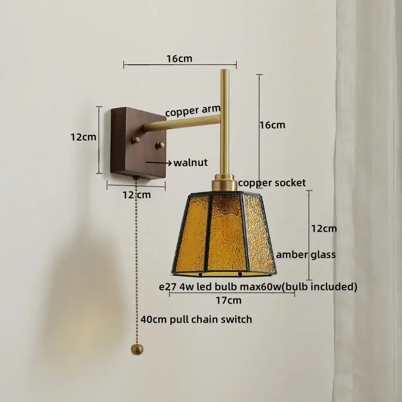 Modern brass and amber glass copper led wall lights featuring a warm amber glass lamp with copper arm on walnut plate