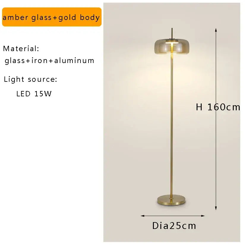 A sleek amber glass and brass led floor lamp with a slender metal stem for modern living room lighting