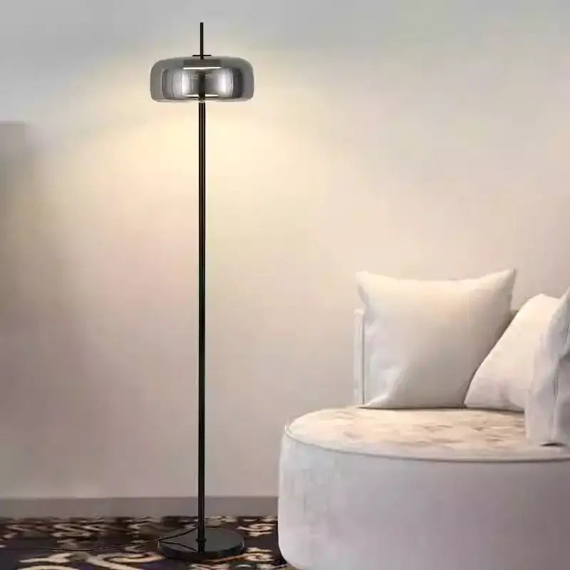 Modern brass and amber glass led floor lamp with sleek chrome shade and black metal pole for living room lighting