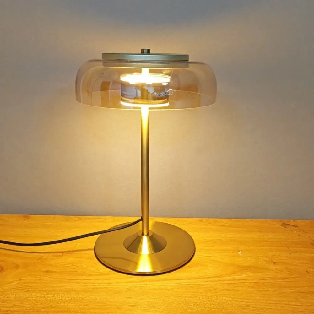Modern brass and amber glass mushroom table lamp with sleek stem and glass dome for warm bedroom decorbites elegant mushroom light
