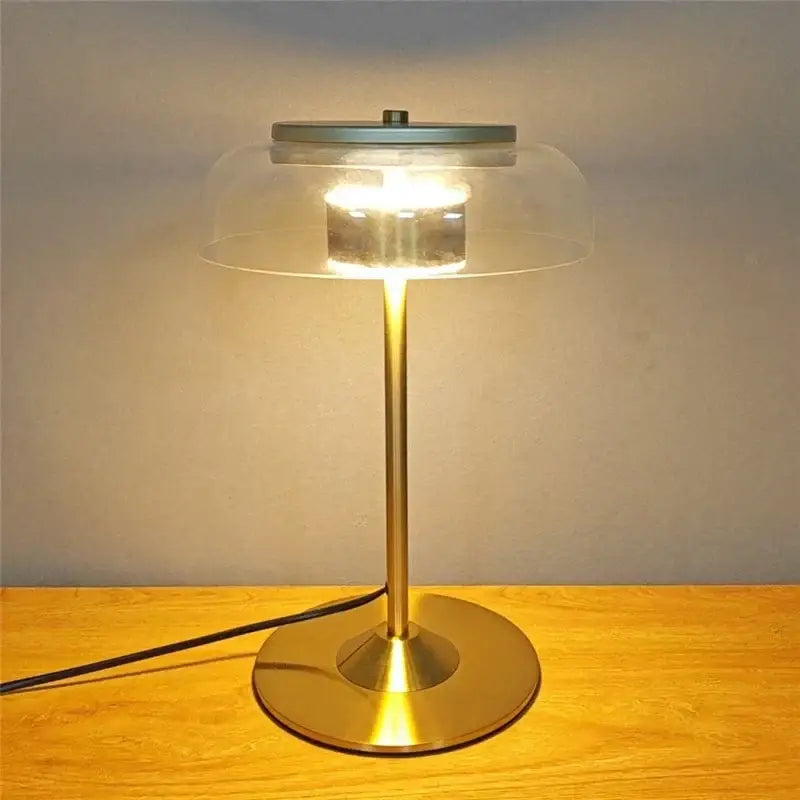A sleek brass-finished table lamp with transparent amber glass dome from decorbites elegant mushroom glass collection