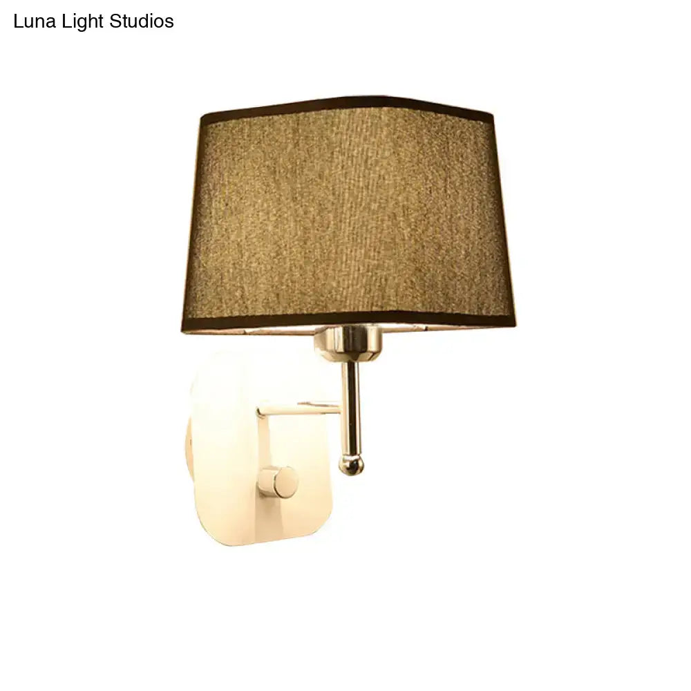 A modern brass and beige linen wall sconce with a textured fabric shade and polished metallic arm for sconce lighting