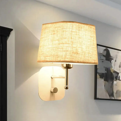 Modern brass and beige linen wall sconce lighting featuring a warm-toned rectangular fabric shade with textured finish