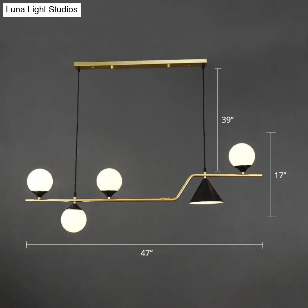 Modern brass ball hanging island light with three frosted glass globes and one black conical shade for dining room