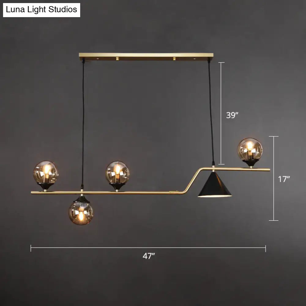 DecorBites™ minimalist gold metal ball hanging island light with three amber glass bulbs and one black conical shade