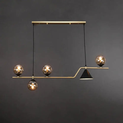Modern brass pendant light with three amber glass ball hanging bulbs and one black conical shade for dining island